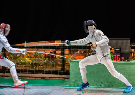 Fight at a fencing competition. Two fencing athletes fight on professional sports arena