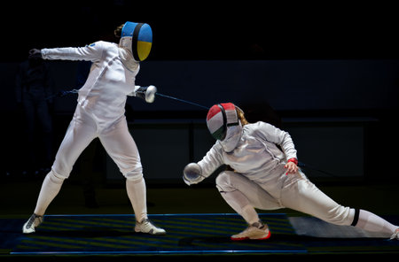 Two female fencing athletes fighting on professional sports arena