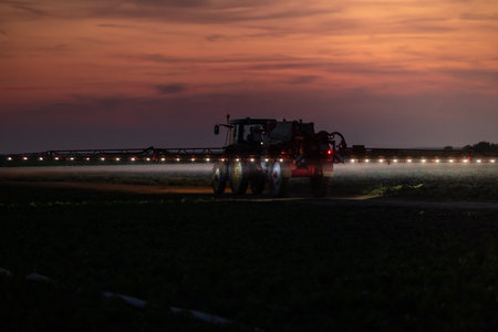 Tractor spraying pesticides on vegetable field with sprayer at springの写真素材