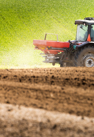 Tractor spreading artificial fertilizers. Transport, agricultural.の写真素材