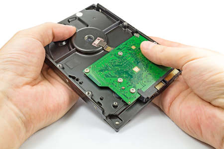 Hard disk drive in the engineer's hands on a white background