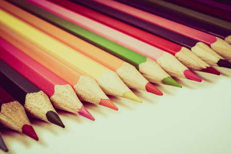 Wooden coloured pencils arranged in a row, toned imageの写真素材