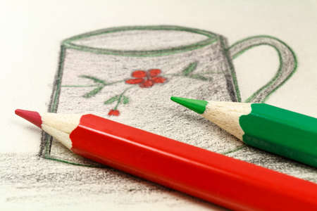 Red and green pencils on the background of a children's drawingの写真素材