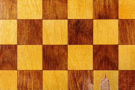 Fragment of a old wooden chess board closeup. Abstract backgroundの写真素材