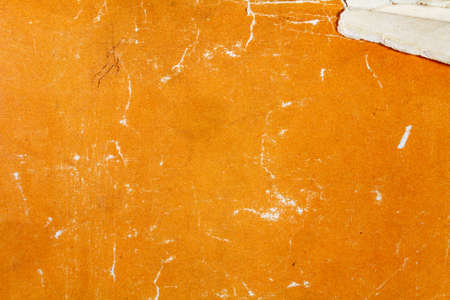 Fragment of a vintage orange paper texture with scrapes and damages. Abstract backgroundの写真素材