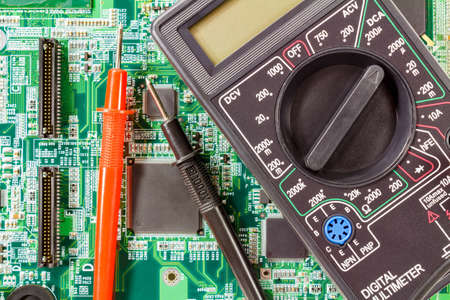 Digital multimeter and probes on a green circuit board closeupの写真素材
