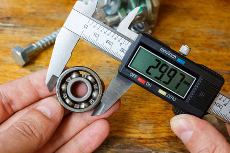 Measuring the outer diameter of a ball bearing with an electronic caliperの写真素材
