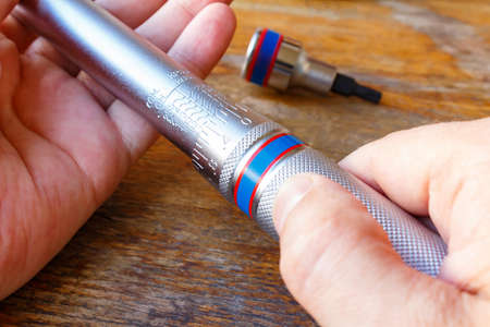 Torque wrench in the mechanic hands closeup