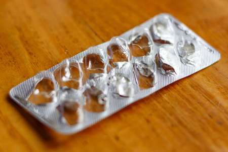 Empty blister pack from tablets on a wooden tableの写真素材