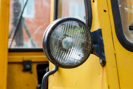 Old yellow forklift truck front headlight closeupの写真素材