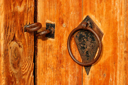 Fragment of old vintage wooden door with padlock rings and handle closeupの写真素材