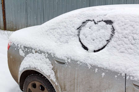 Drawn heart on the snowy car windshieldの写真素材