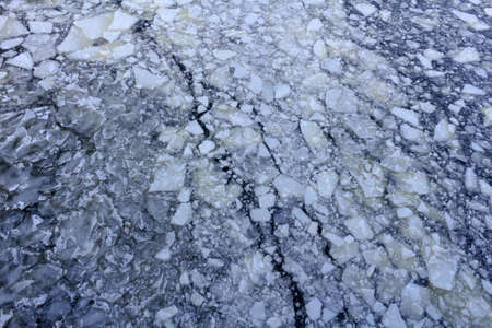 Broken ice on the surface of the river in winter. Ice floes texture