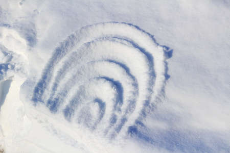 Abstract drawing on snow on a sunny winter dayの写真素材
