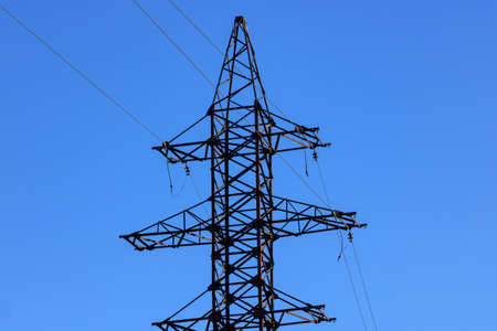 Power line support against blue sky background