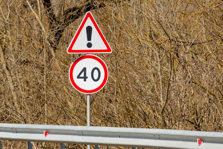 Road signs background of bushes Danger ahead and Speed limit 40の写真素材