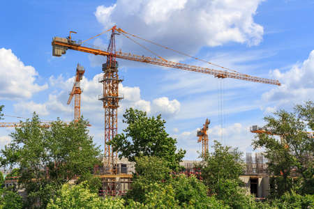High-rise cranes at the construction site against blue skyの写真素材