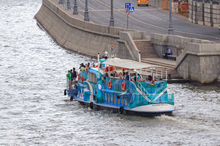 Moscow, Russia - June 19, 2018: Pleasure boat floating with tourists on a background of embankment of Moskva river on a cloudy summer eveningのeditorial素材