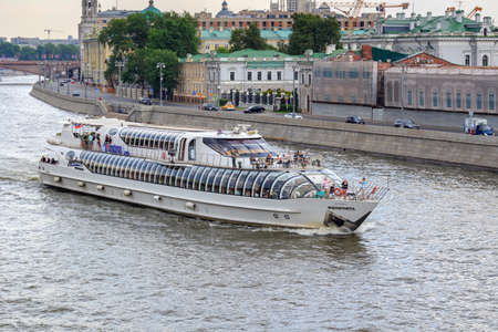 Moscow, Russia - June 19, 2018: Pleasure boat floating on Moskva river against embankment on a cloudy summer eveningのeditorial素材