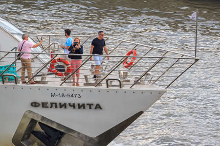 Moscow, Russia - June 19, 2018: Tourists on pleasure boat takes a photo on a background of Moskva river embankmentのeditorial素材