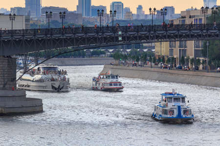 Moscow, Russia - June 19, 2018: Pleasure boats floating on Moskva river on a background of Patriarshiy bridge on a cloudy summer eveningのeditorial素材