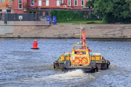 Moscow, Russia - July 30, 2018: Loaded barge floating against Moskva river embankment on a sunny summer dayのeditorial素材