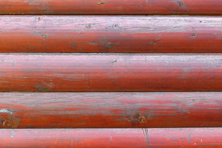 Red painted smooth logs texture closeup. Abstract wooden backgroundの写真素材