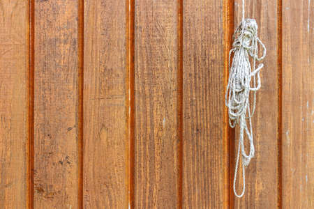 Brown painted wooden planks with rope coil. Abstract wooden background