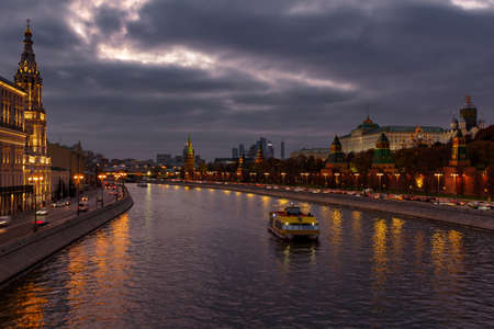 Moscow, Russia - October 20, 2018: Pleasure boat on Moskva river near Moscow Kremlin in evening on a...