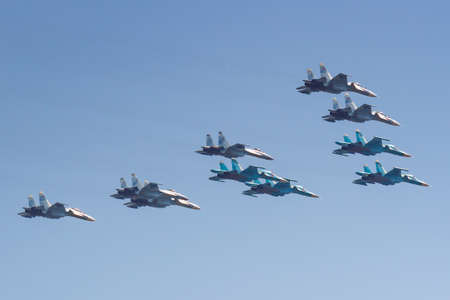 Moscow, Russia - May 07, 2019: Fighters Su-35S and Su-30SM with bombers Su-34 in the blue sky over...