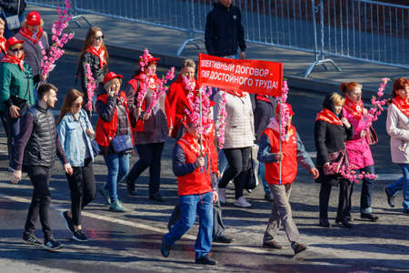 Moscow, Russia - May 01, 2019: Peoples with banner and flowers go to the May Day demonstration on...