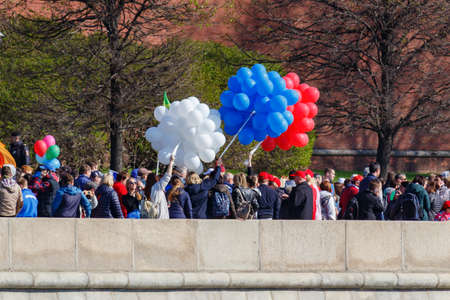 Moscow, Russia - May 01, 2019: Demonstrators with colored balloons on Kremlevskaya embankment against Kremlin wall. May Day celebration in Moscowのeditorial素材
