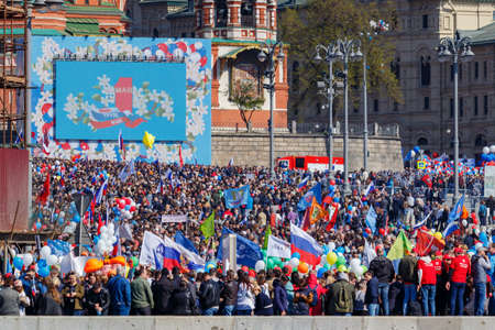Moscow, Russia - May 01, 2019: Peoples with flags and colored balloons near St. Basils Cathedral on...