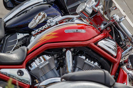 Moscow, Russia - May 04, 2019: Fragment of chrome engine and bright red fuel tank with Harley Davidson motorcycles emblem closeup. Moto festival MosMotoFest 2019のeditorial素材