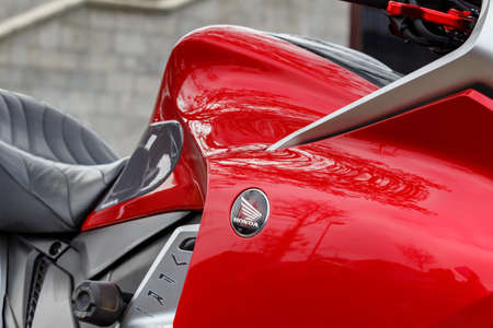 Moscow, Russia - May 04, 2019: Glossy red fuel tank of sports motorcycle with Honda emblem closeup....