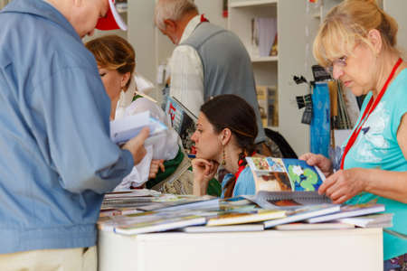 Moscow, Russia - June 02, 2019: Festival visitors and consultants of book publishers communicate on...