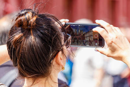 Moscow, Russia - June 02, 2019: Woman takes a photo on the modern smartphone on Red Square in Moscow...