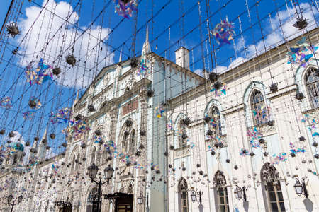 Moscow, Russia - July 28, 2019: Facade of Synodal printing house on Nikolskaya street in Moscow against decorative garlands and blue sky with white clouds at sunny summer morningのeditorial素材