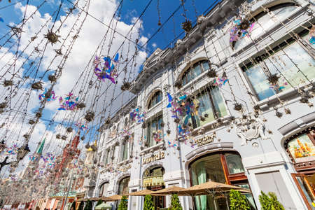 Moscow, Russia - July 28, 2019: View of restaurant LADUREE facade on Nikolskaya street in Moscow against decorative garlands and blue sky with white cloudsのeditorial素材