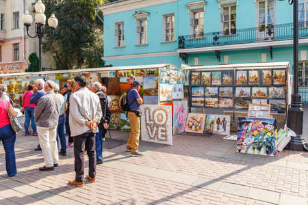 Moscow, Russia - September 13, 2019: Tourists on Arbat street in Moscow against stand with paintingsのeditorial素材