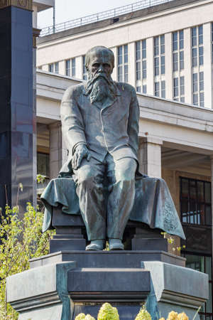 Moscow, Russia - September 13, 2019: Monument to the classic of russian literature Fyodor Dostoevsky on a Russian state library buildings background in sunlightのeditorial素材