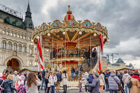 Moscow, Russia - October 05, 2019: Two-storey carousel against GUM State Department Store building on Red Square at cloudy autumn day. Traditional festival Golden Autumn in Moscowのeditorial素材