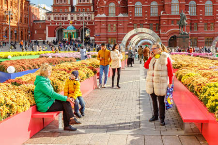 Moscow, Russia - October 08, 2019: People on alley among the flowers at sunny autumn day on the traditional festival Golden Autumn on Manezhnaya Square in Moscowのeditorial素材