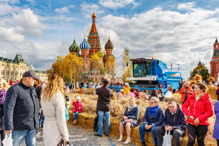 Moscow, Russia - October 05, 2019: People resting on the benches made of straw on Red Square in Moscow. Decorative installations of the traditional festival Golden Autumnのeditorial素材