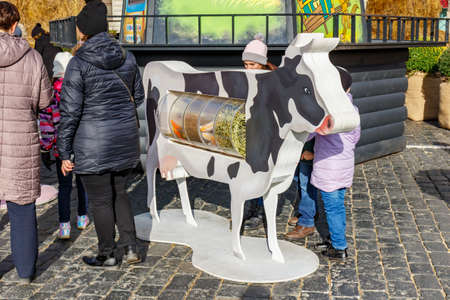 Moscow, Russia - October 08, 2019: Visitors of traditional festival Golden Autumn on Red Square in Moscow near decorative cow in sunny autumn dayのeditorial素材