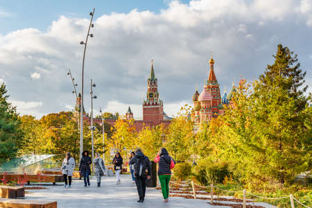 Moscow, Russia - October 08, 2019: Tourists walking along footpath in Zaryadye Park in Moscow at sunny autumn day. View on a Moscow Kremlin backgroundのeditorial素材