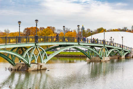 Moscow, Russia - October 16, 2019: People walk on a pedestrian bridge above Middle Pond in Tsaritsyno Park at cloudy autumn day. Tsaritsyno Park is popular touristic place in Moscowのeditorial素材