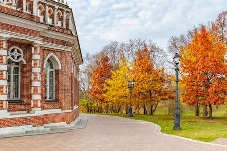 Moscow, Russia - October 16, 2019: Autumn in Tsaritsyno Park in Moscow. Trees with bright colored leaves against facade of restored historical building on a cloudy autumn sky backgroundのeditorial素材