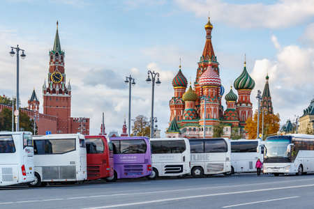 Moscow, Russia - October 08, 2019: Tourist buses parked on Red square in sunny autumn evening. Red...