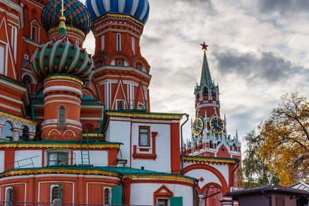 Moscow, Russia - October 08, 2019: Colored domes of Saint Basil Cathedral on Red square close-up against Spasskaya tower of Moscow Kremlin in cloudy autumn eveningのeditorial素材